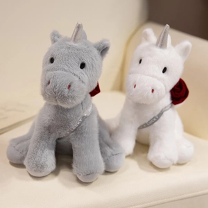 Plush unicorn dolls with rose and Lucky ribbon on a soft leather sofa background