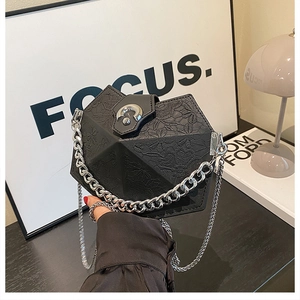 Detail of geometric embossed black leather bag with silver chunky chain and metal lock