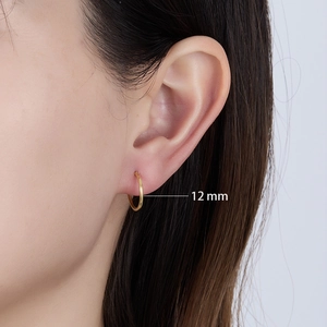 Close-up of 12mm 925 sterling silver gold hoop earring worn on a woman's earlobe