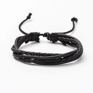 Detail of adjustable black multilayer braided leather bracelet for men with Tai Chi design