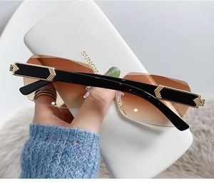 Detail of rimless gradient brown sunglasses with gold arrow accents and leather case