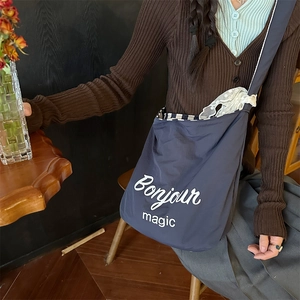 Detail of navy nylon tote bag with Bonjour magic print and striped lace interior