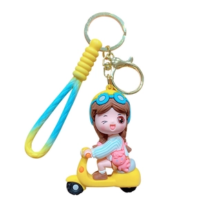 Cartoon girl riding a yellow scooter keychain with a colorful silicone wristlet strap