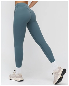 Detail view of high-waist yoga leggings in teal highlighting body-sculpting fit and seams