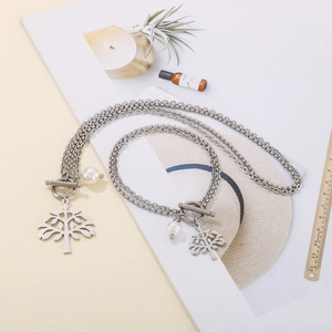 Detail of silver tree of life pendant with double layer steel chain and pearl accent