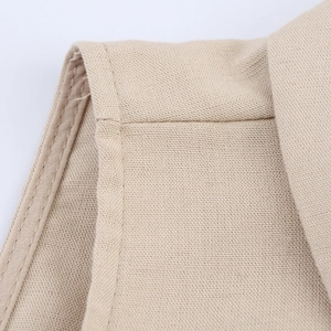 Makroaufnahme des beigen Leinenimitats mit detaillierten Nähten am ärmellosen Kleid