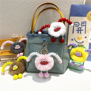 Colorful plush monster keychains with large eyes on a denim bag, set of five colors