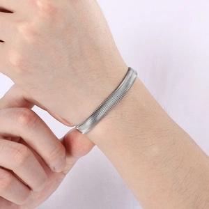 Polished silver stainless steel flat snake bone chain bracelet worn on a wrist