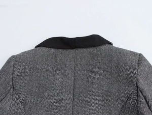 Detailed macro view of black and white herringbone wool fabric and contrast collar
