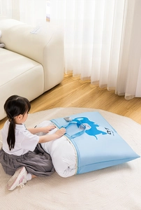 Detail of large capacity blue storage bag with elephant print holding a white quilt