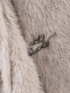 Close-up of the invisible hook closure and plush faux fur texture on the beige coat