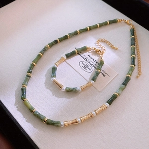 Detail of vintage bamboo style jewelry set with green resin beads and gold accents