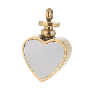 Detailed close-up of a heart-shaped pendant in polished gold metal with white filling