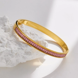 Detail of gold-plated stainless steel bangle with emerald-cut pink crystals on stone