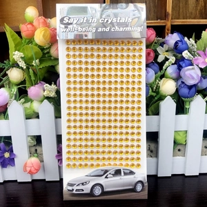 Close-up of golden acrylic crystal rhinestone stickers with card packaging for DIY decor
