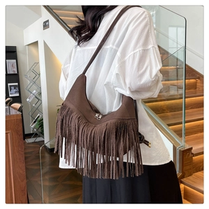 Détail du sac hobo marron avec de longues franges en daim et des fermetures éclair