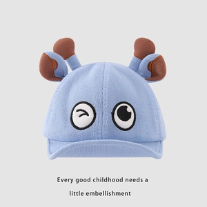 Détail de la maille du bonnet bébé bleu clair avec des yeux de dessin animé et des bois
