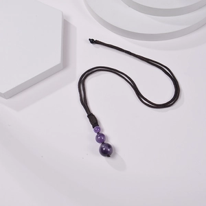 Close-up of three purple amethyst beads on a dark brown braided cord necklace detail