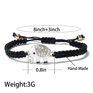 Handmade woven black rope elephant bracelet with crystals and gold beads on white background