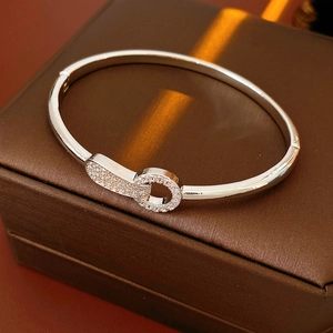 Detail view of silver clasp bracelet with pave cubic zirconia on a luxury gift box