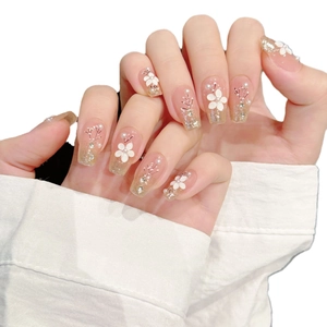 Elegant long coffin press-on nails with pink cat eye base, white flowers, and glitters