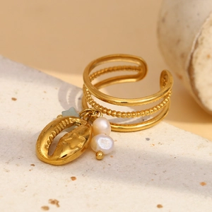 Detailed close-up of an 18K gold-plated ring featuring a shell charm and white pearls