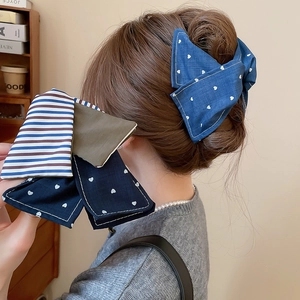 Détail de pinces à cheveux en tissu fait main avec motifs de cœurs et rayures