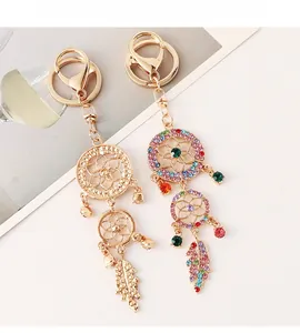 Detail of dreamcatcher keychains featuring rhinestones, metal feathers and small bells