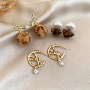 Set of 3 French vintage earrings with leopard print and pearls on silk background