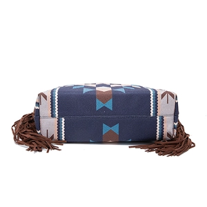 Detailed bottom view of a bohemian woven tote bag showing stitching and brown tassels