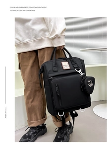 Detailed view of black multi-functional backpack featuring a heart-shaped cake charm