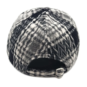 Detail of black and white plaid wool baseball cap featuring adjustable silver metal buckle