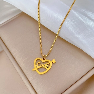 Gros plan détaillé du pendentif cœur fléché doré avec gravure LOVE et chaîne box