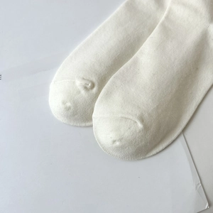 Detail shot of white cotton mid-calf socks showing fine knit texture and reinforced toe