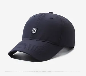 Detail view of navy blue baseball cap featuring a high-quality embroidered H patch