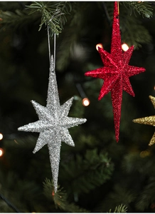 Detailed view of red and silver glittery octagonal star ornaments hanging on a Christmas tree