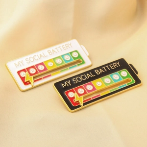 Detail of My Social Battery enamel pins with sliding gold lightning bolt pointers