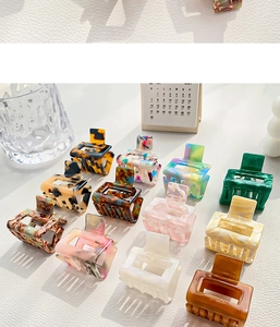 Detailed overhead view of premium acetate hair claws in various marble and tortoiseshell patterns