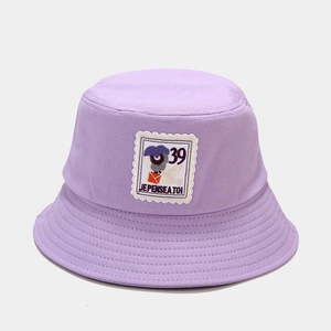 Detail of light purple cotton bucket hat with a stamp-style patch and embroidery