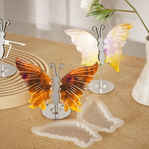 Detailed view of butterfly resin mold with DIY craft finished pendants on wooden table