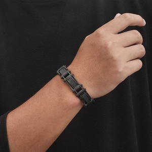Détail d'un bracelet de moto en acier inoxydable noir porté sur un poignet