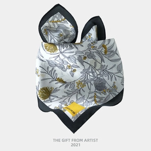 Detailed view of luxury silk neckerchief with floral pattern and creative rabbit ear fold