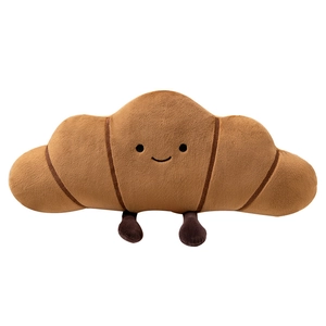 Coussin peluche croissant mignon avec visage souriant et petites pattes sur fond blanc