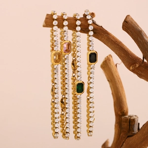 Detailed view of 18K gold plated tennis bracelets with green pink yellow stones