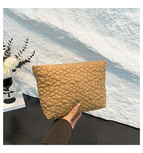 Detail of khaki quilted floral fabric pouch with soft padded texture and elegant finish