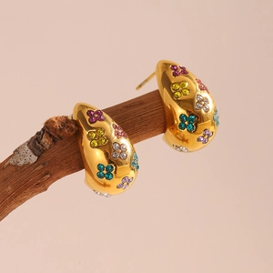 Detailed view of 18K gold plated floral earrings with colorful crystals on a branch