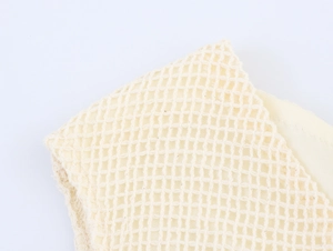 Nahaufnahme des beigen Häkelnetzes und der hohlen Stricktextur des langen Kleides