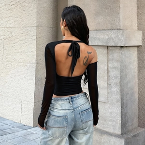 Detail of a black open back long-sleeve top with halter tie neck and slim fit design