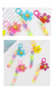 Detail of colorful acrylic chain keychain with smiling flower and gummy bear pendants