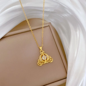 Detailed macro view of a gold pumpkin carriage pendant inlaid with sparkling crystals